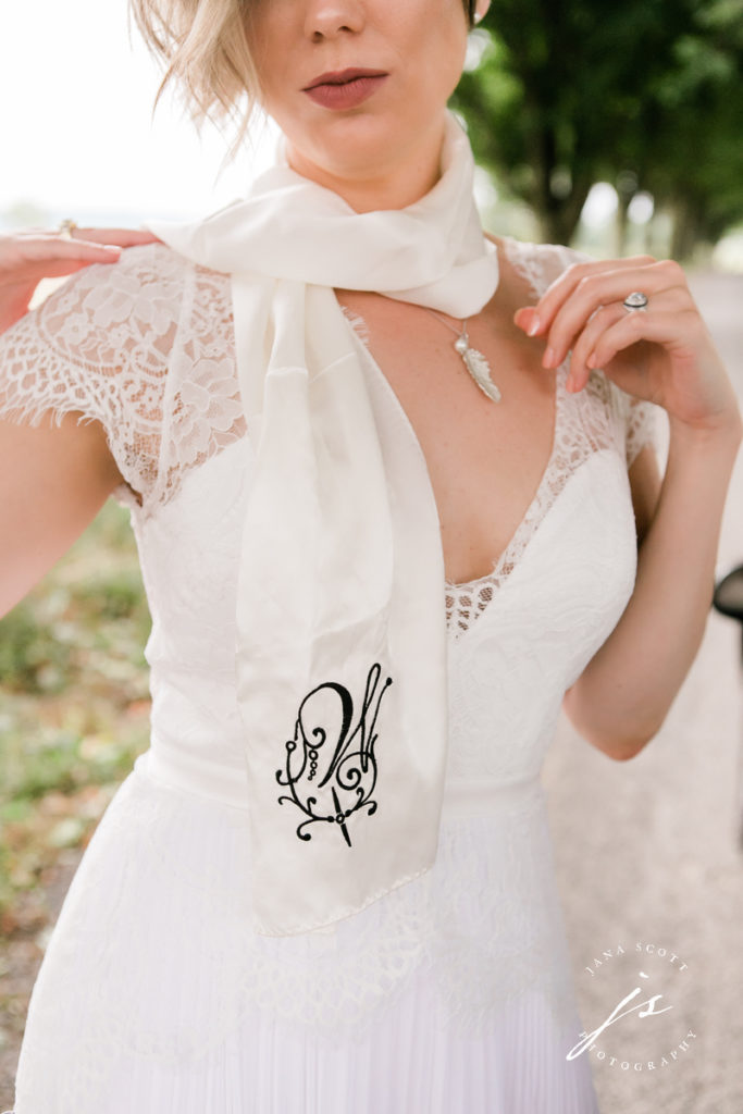 close up of bride's scarf and necklace while she is wearing them