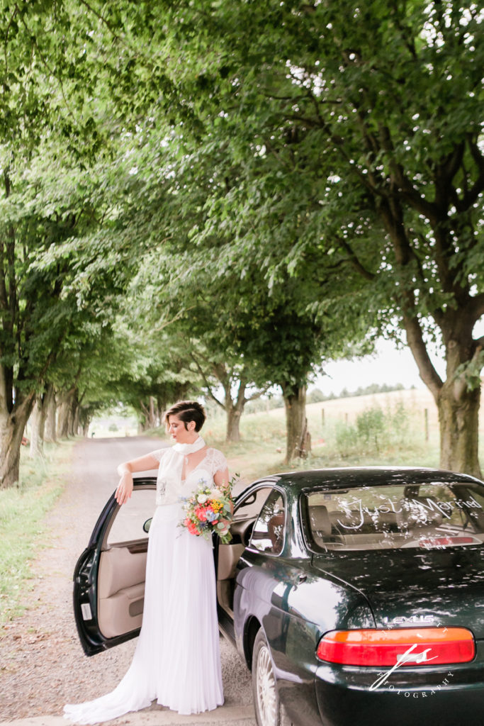 bride posing outside of her car
