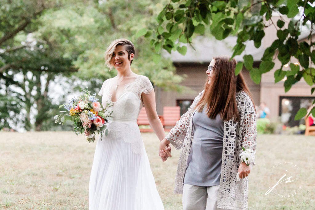 bride smiling and walking with her mom to the altar