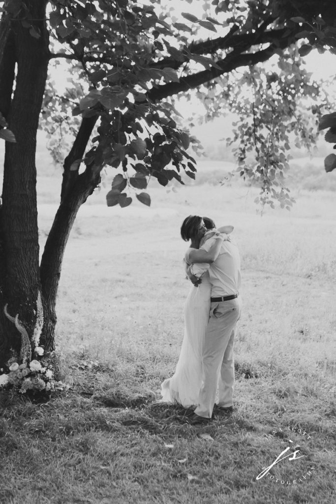 black and white photo of bride and groom hugging after their ceremony