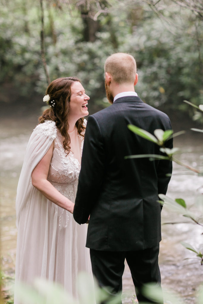 Bride laughs while reading vows to groom privately by a stream