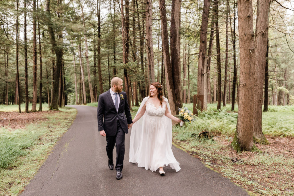 bride and groom skip down a paved path