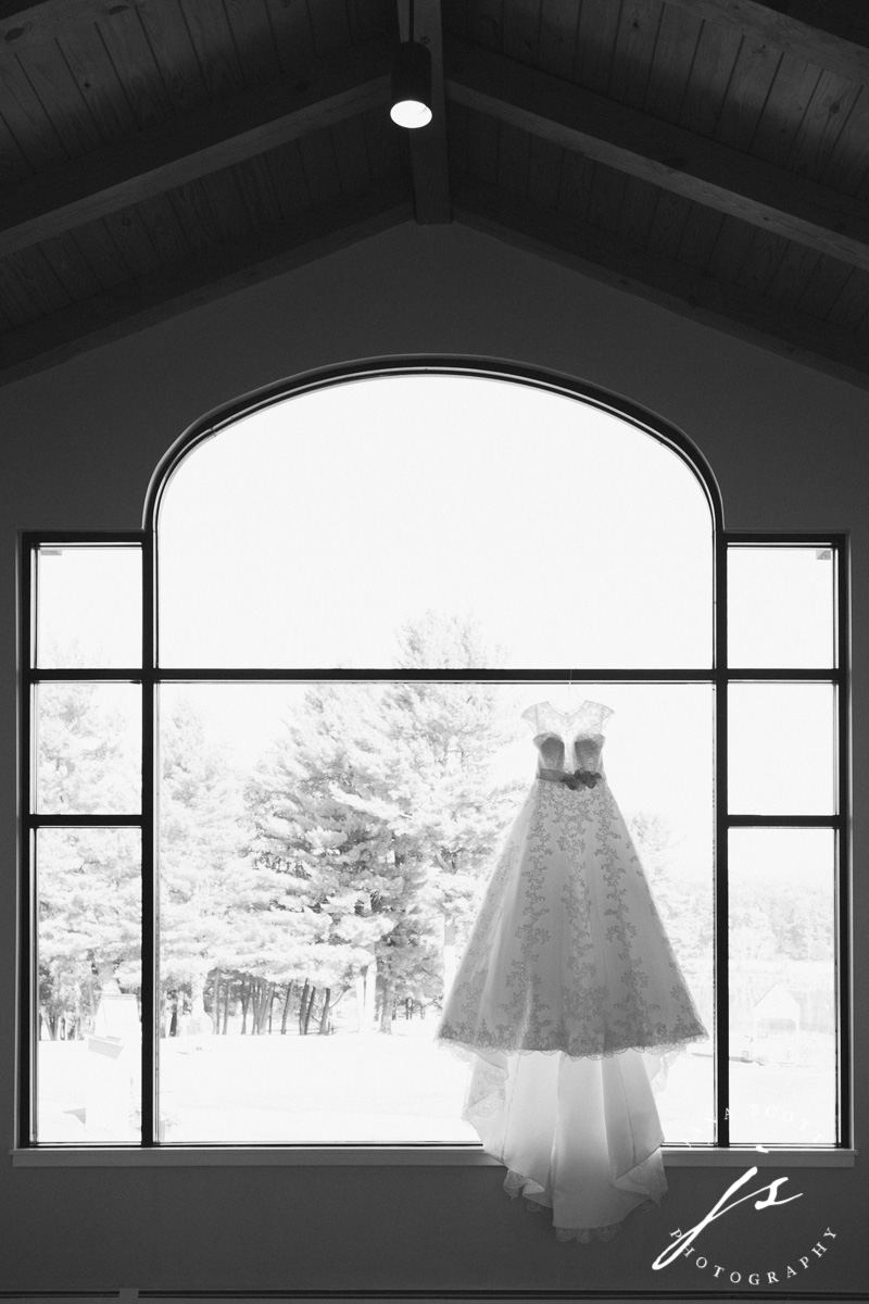 Wedding dress hanging in front of picture window