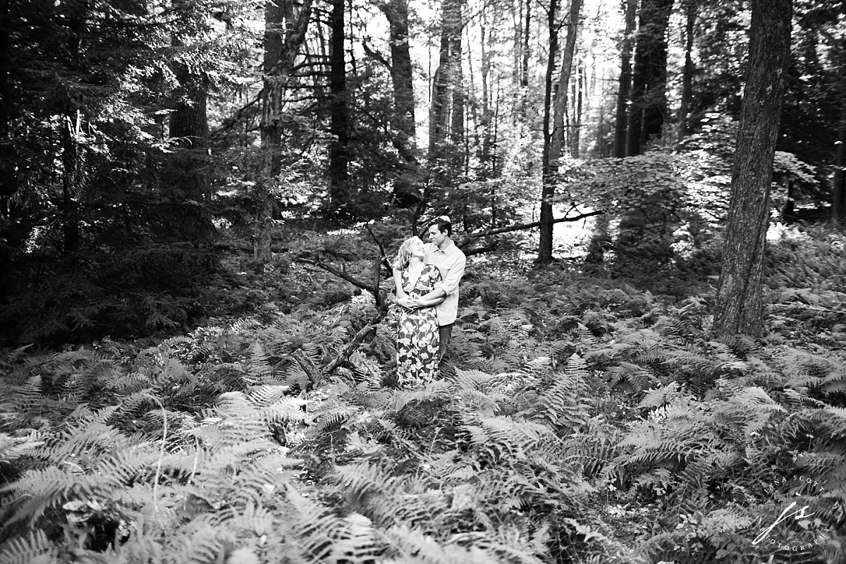 black and white enagement photo in the woods