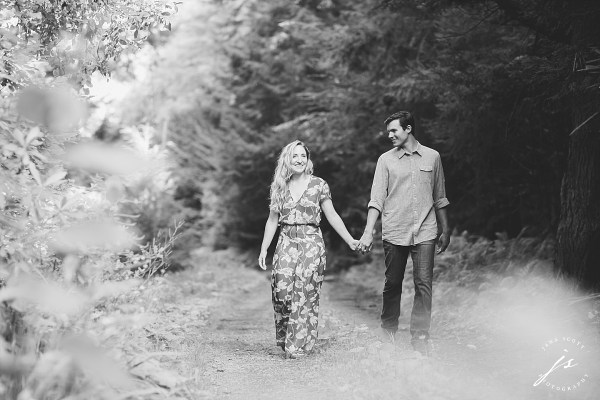couple smiling and walking in the woods
