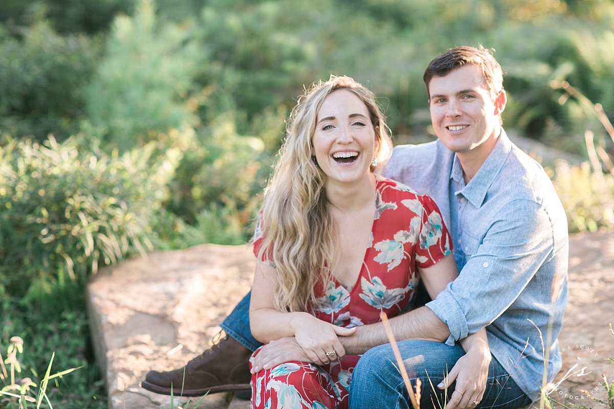 couple sitting on a rock laughing