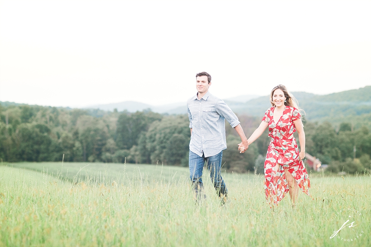 couple running in a field for engagement session photos