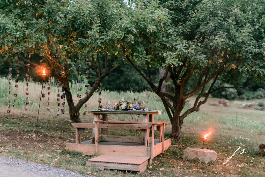 picnic table wedding reception in the evening with torches lit