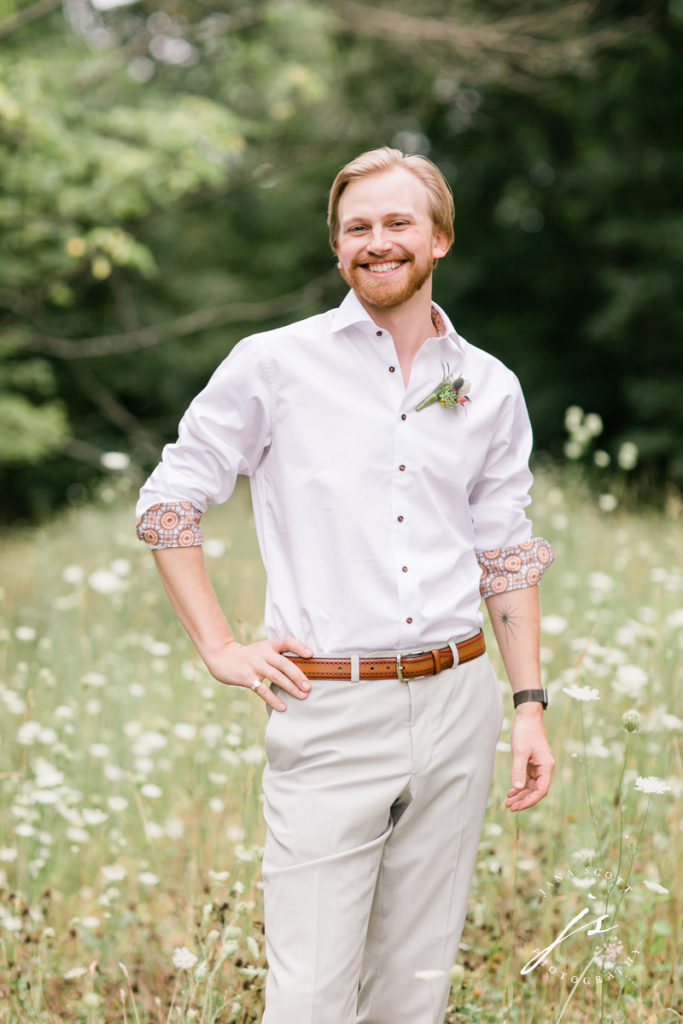 groom smiling with hand on hip