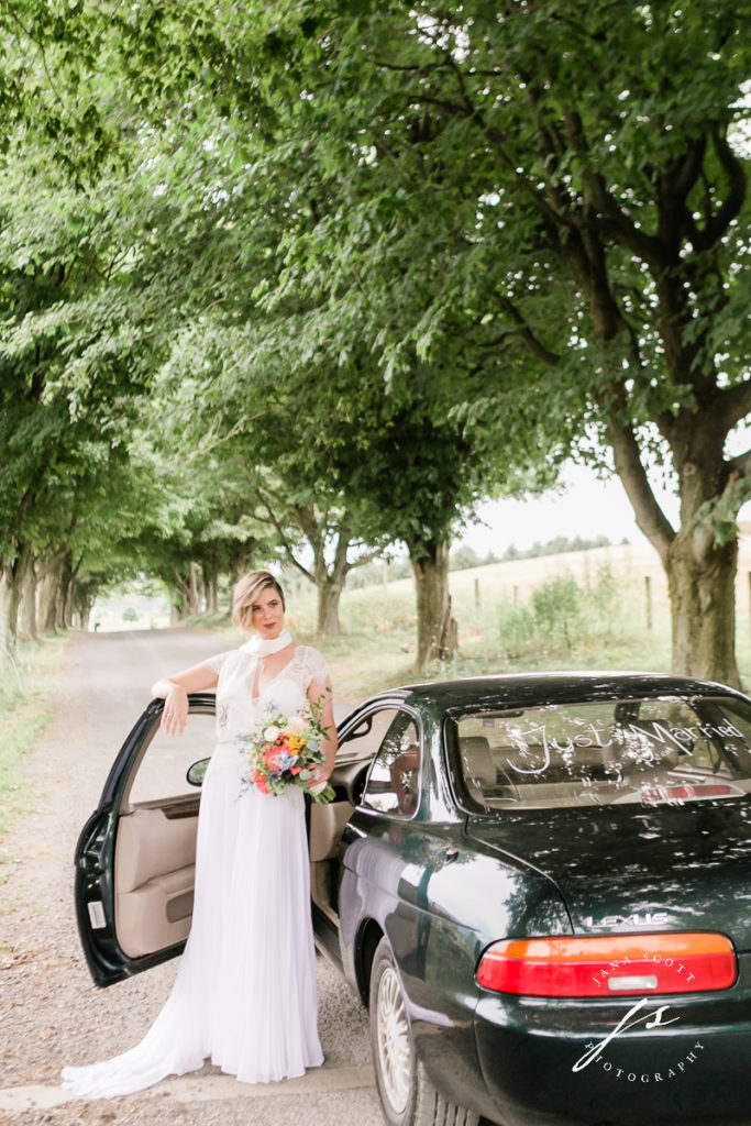bride looking at the camera outside of her car