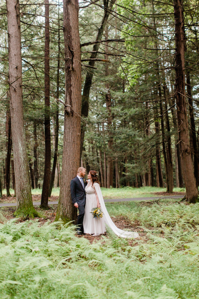 Bride and groom in fern covered forest