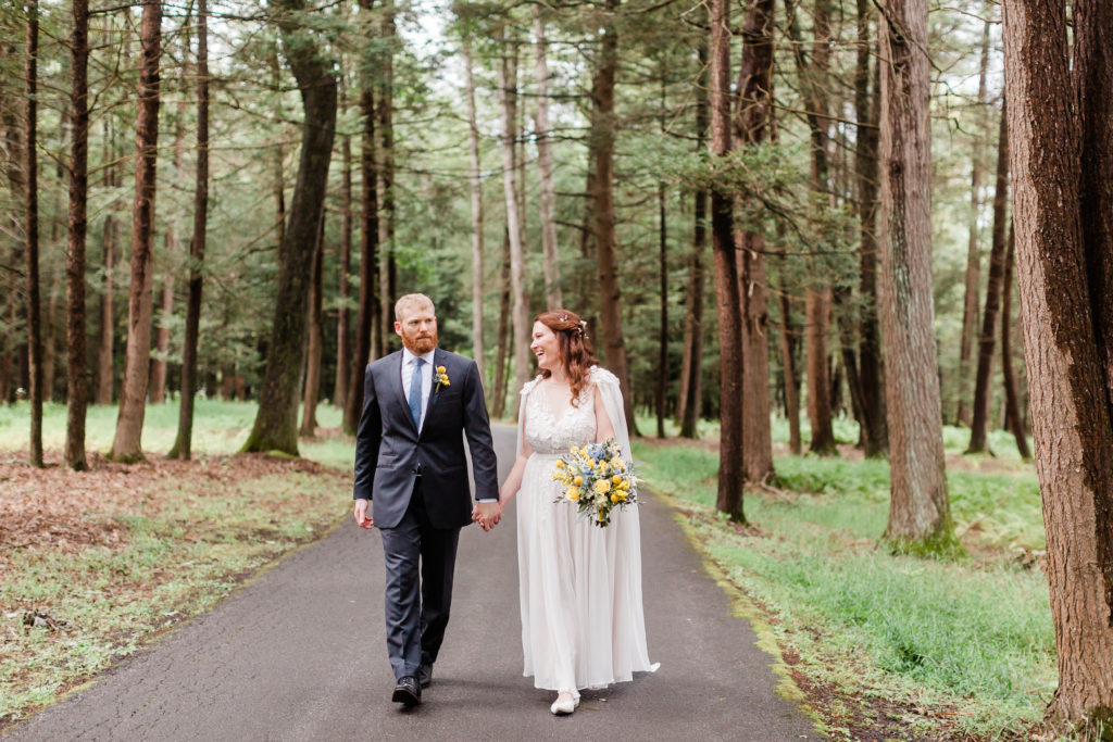 bride and groom skip down a paved path