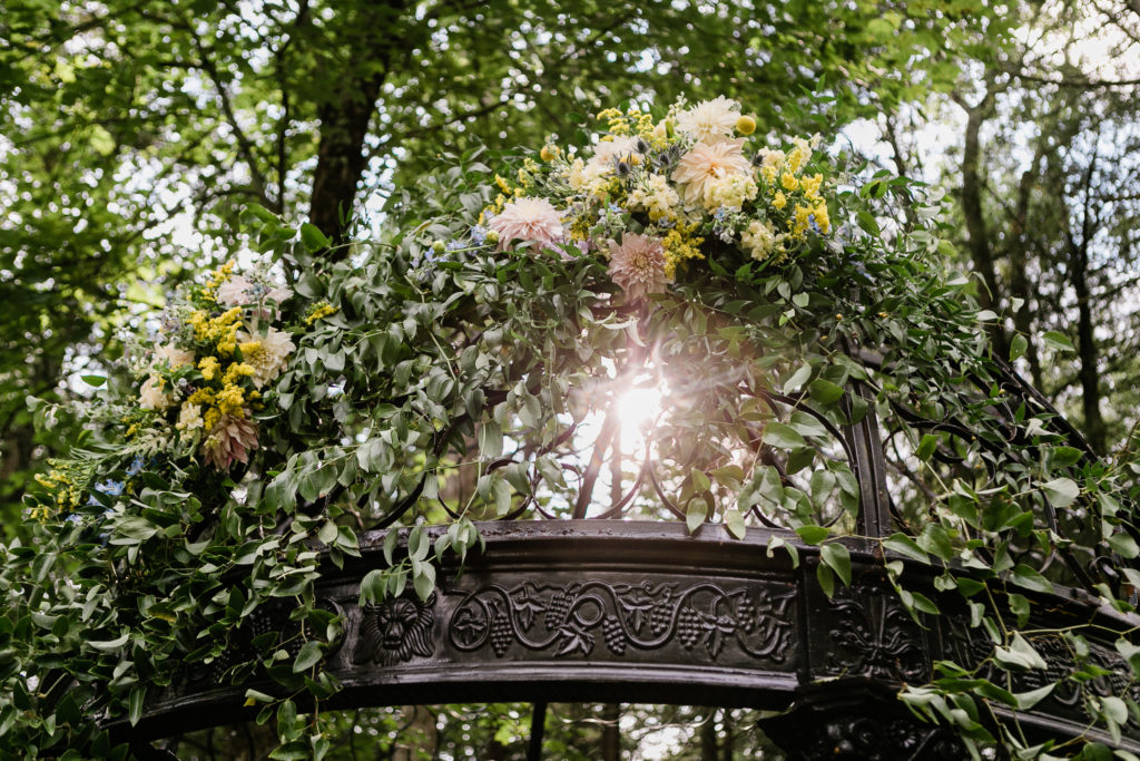 Flowers on Wedding ceremony arch with sunlight peaking through