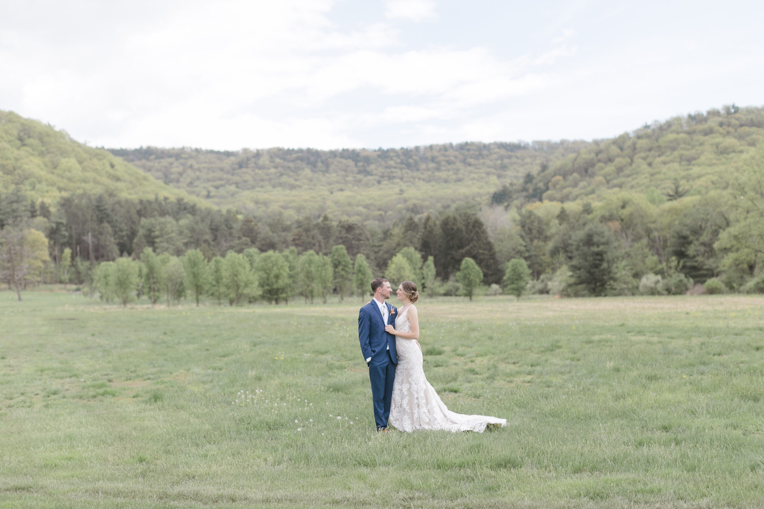 Mike and Allison in a field with mountains in the background on their wedding day