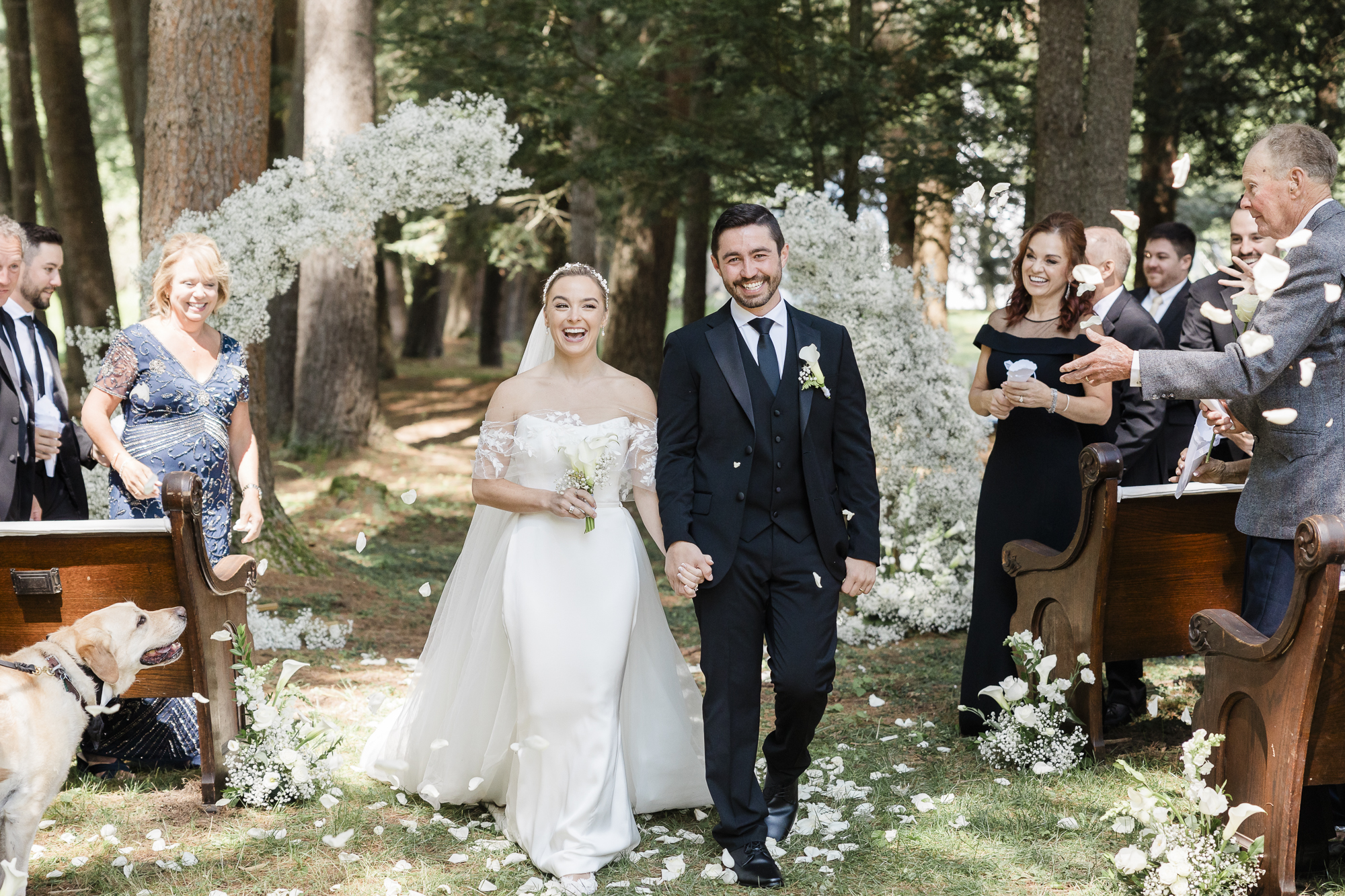 Bride and groom exit their wedding ceremony in a hemlock grove